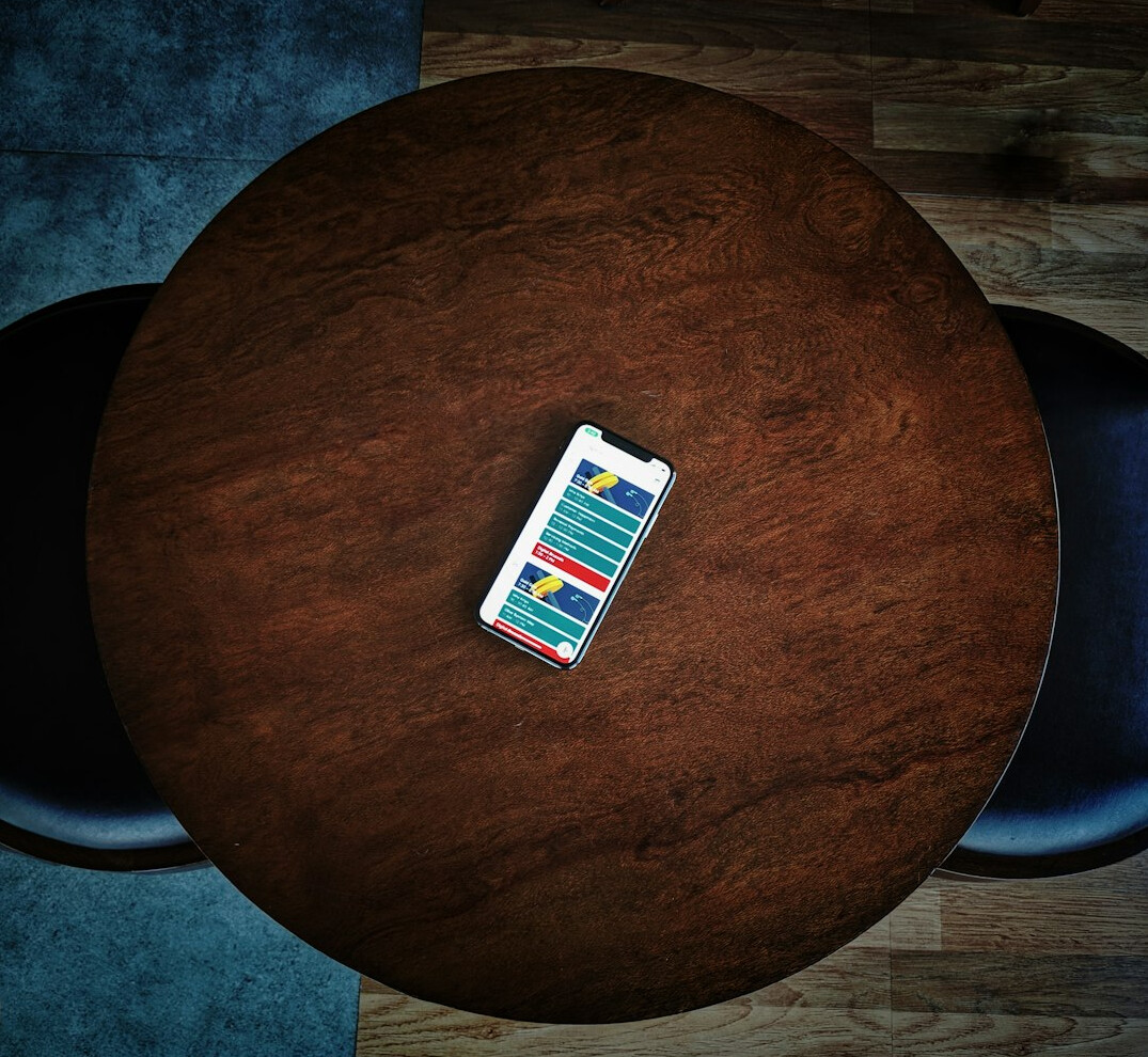 Printed survey questionnaires and clipboard with pen on a wooden table beside a laptop